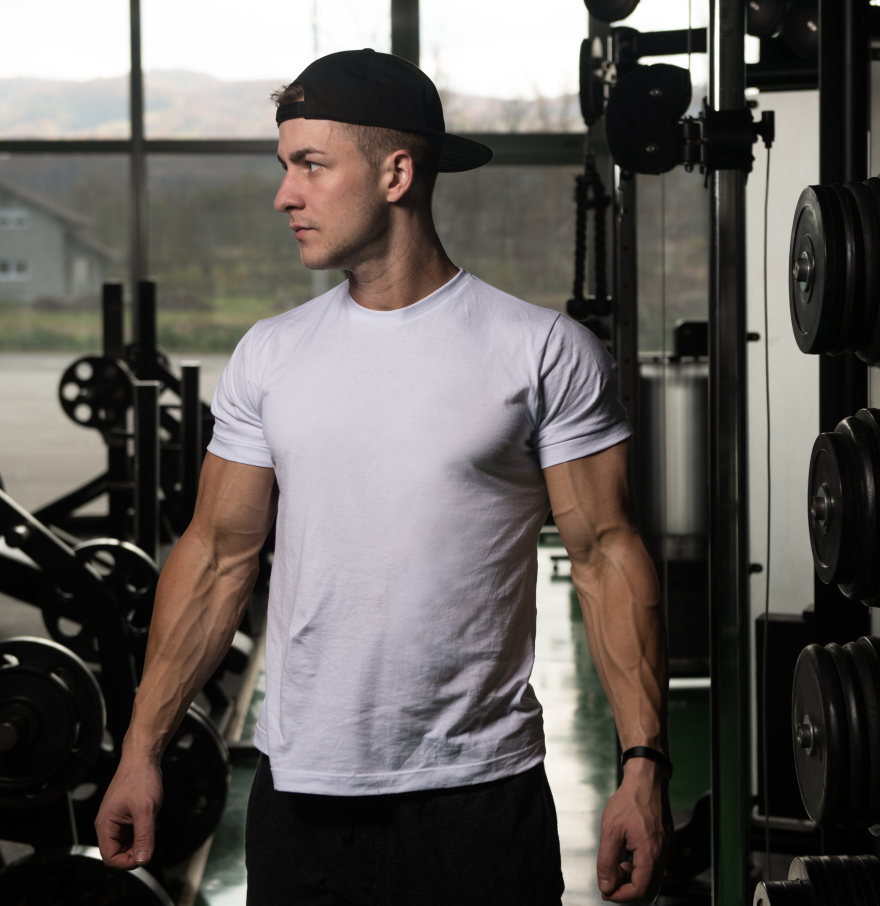 Young man in black tank top wearing SQUATWOLF cap in gym